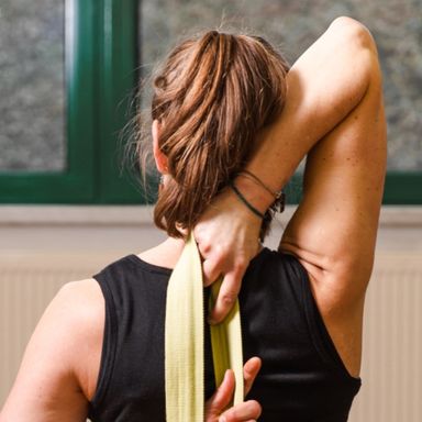 sitzende Yogaasana Kuhmaulgesicht mit Hilfsmittel Gurt